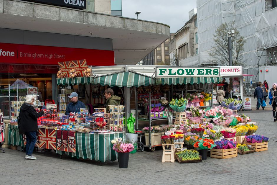 A vibrant outdoor flower stall near Birmingham High Street, managed by floristbromleycommon.co.uk, displaying an assortment of freshly cut flowers arranged in bouquets and bouquets wrapped in colorful