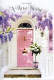 At this Bromley Common entrance, a tender moment of arrival is framed in soft colour and delicate blooms, as though the house itself is quietly saying welcome. A pale pink door sits at the centre, its surface freshly painted yet understated, diffusing the sunlight that drifts across from the nearby green spaces. The surrounding wall is washed in a gentle off-white, its slight imperfections adding a sense of character and homeliness rather than polish. To one side, a matching shutter balances the composition, its simple lines guiding the eye up toward the true spectacle above. There, a generous swath of wisteria spills downward, the blossoms forming long, tumbling bunches in shades of lilac, lavender, and soft purple-grey. The flowers hang like a living curtain, their weighty clusters broken by small pockets of sky-lit space, so the whole arch feels light and breathable despite its abundance. Resting squarely on the doorstep is a grey metal bucket, vintage in feel, packed full with creamy white and ivory-toned roses. Each bloom is round, plush, and gently cupped, the layers of petal catching the afternoon light in subtle gradations from milk white to warm cream. A few stems of muted green foliage peek between them, giving texture and a sense of natural movement. Around the base, a delicate pink ribbon is tied, its tails tumbling loosely across the stone step, perfectly echoing the shade of the front door. The result is a scene that feels ideal for a housewarming or new tenancy in Bromley Common-a floral vignette that radiates kindness, optimism, and the quiet thrill of turning the key in a home that is finally yours.
